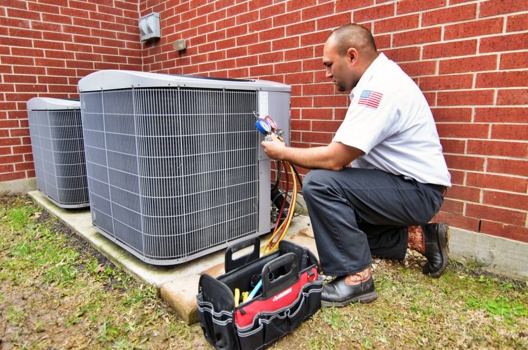 HVAC technician tuning up a homeowner's outdoor air conditioning system