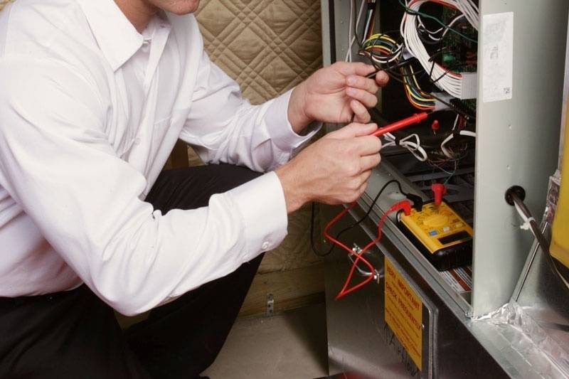 HVAC technician performing a tune-up on a home’s furnace