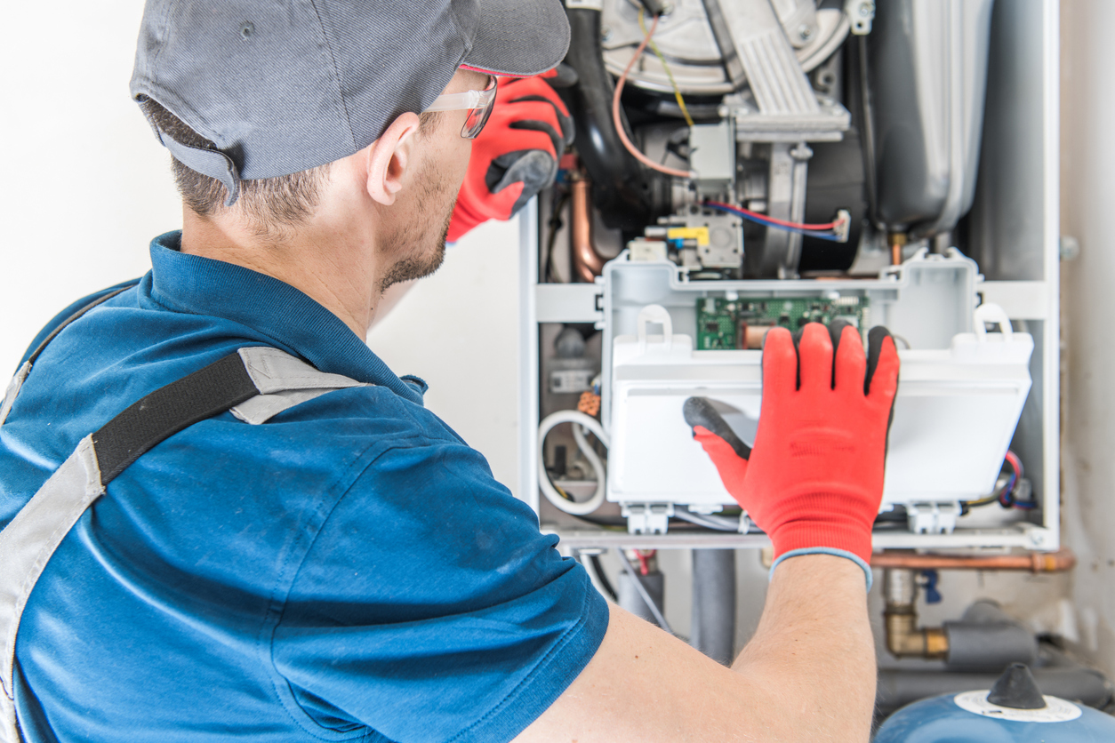 HVAC technician installing a new gas furnace in a Michigan home