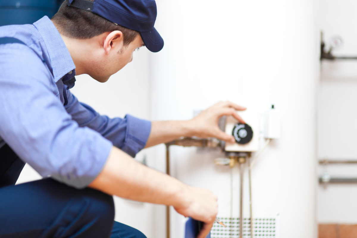 Plumber ensuring a water heater is working after installing it