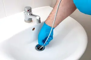 Plumber cleaning sink drain