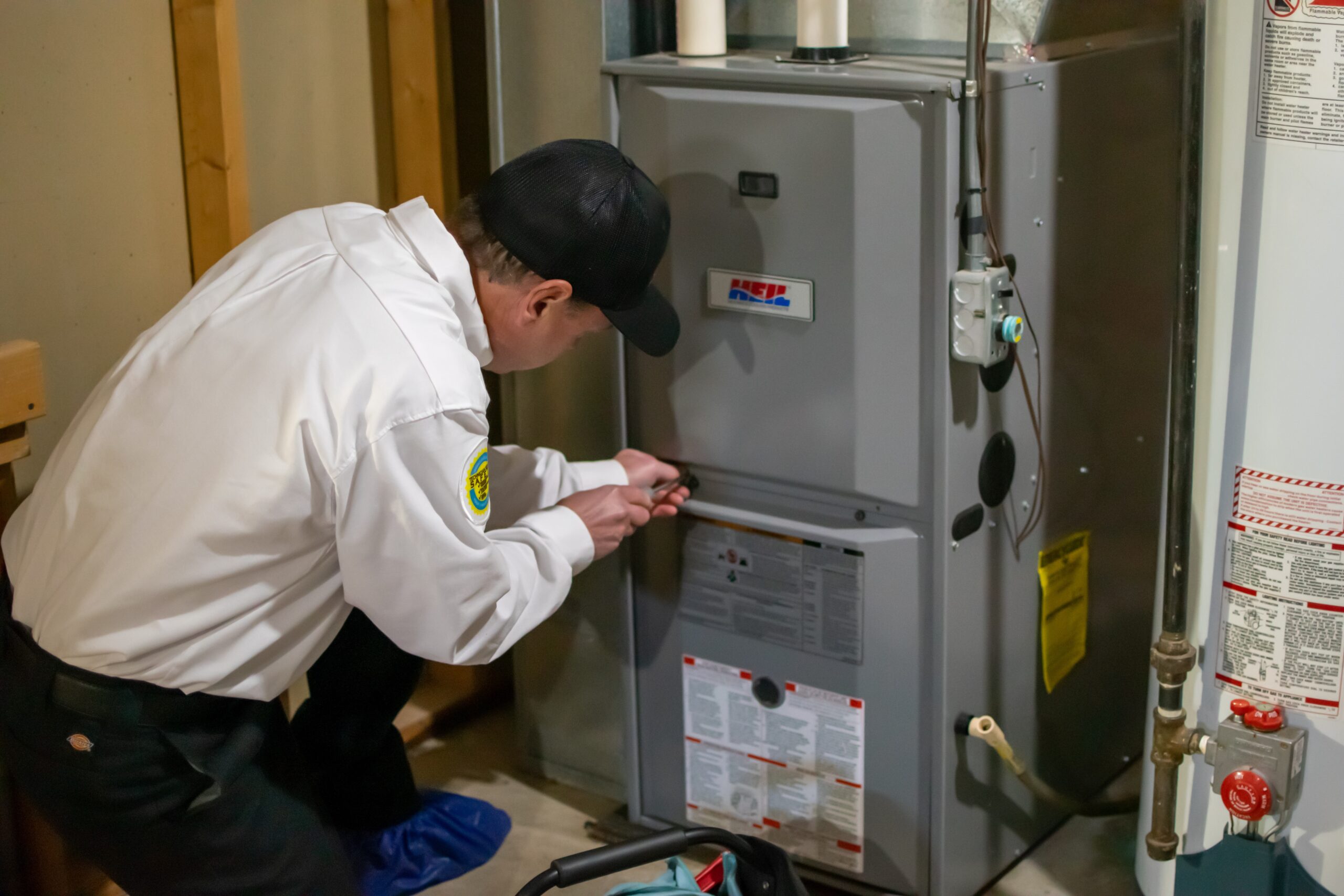 Vredevoogd Heating & Cooling technician servicing an HVAC system in a home.
